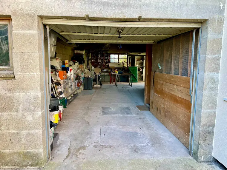 Garage vu depuis la porte, espace atelier et rangement