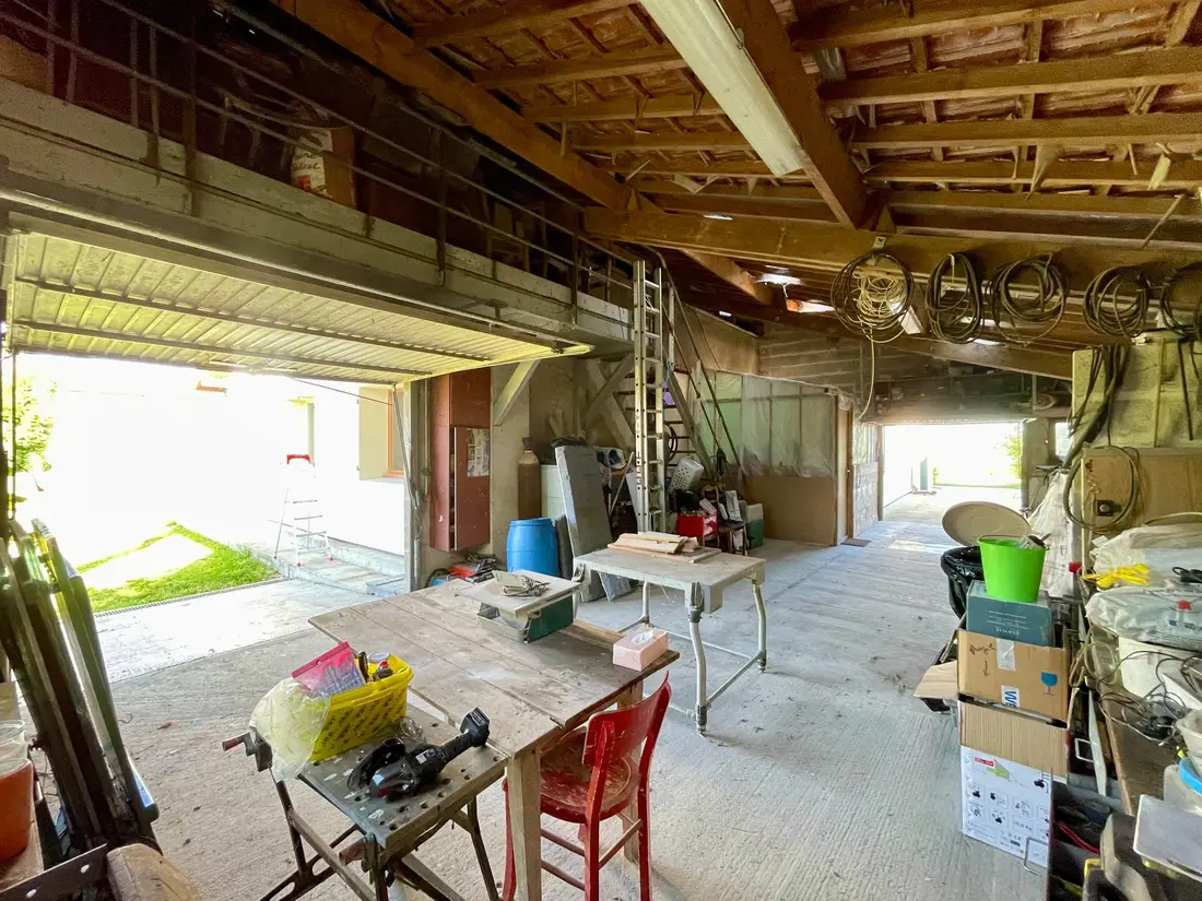 Intérieur du garage de 100 m², charpente et accès au grenier