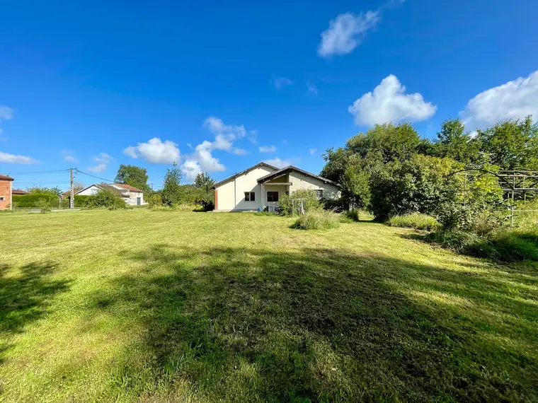 Grande pelouse du terrain de 2 500 m² derrière la maison