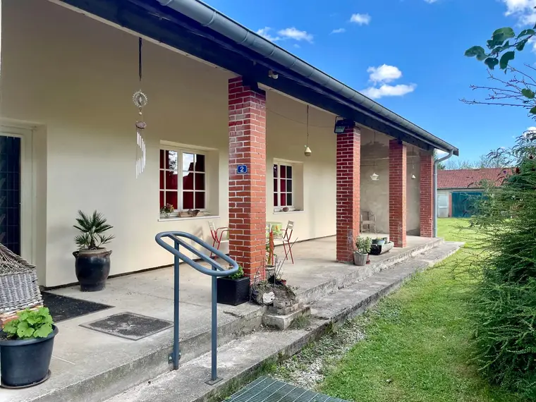 Terrasse couverte devant l’entrée, avec vue sur le jardin